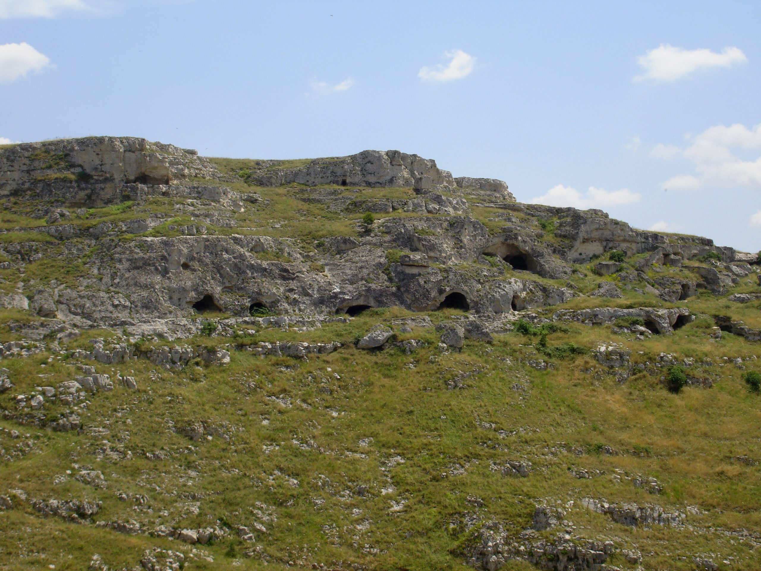 An inhabited cave front in Matera, stone blocks closing an older excavation