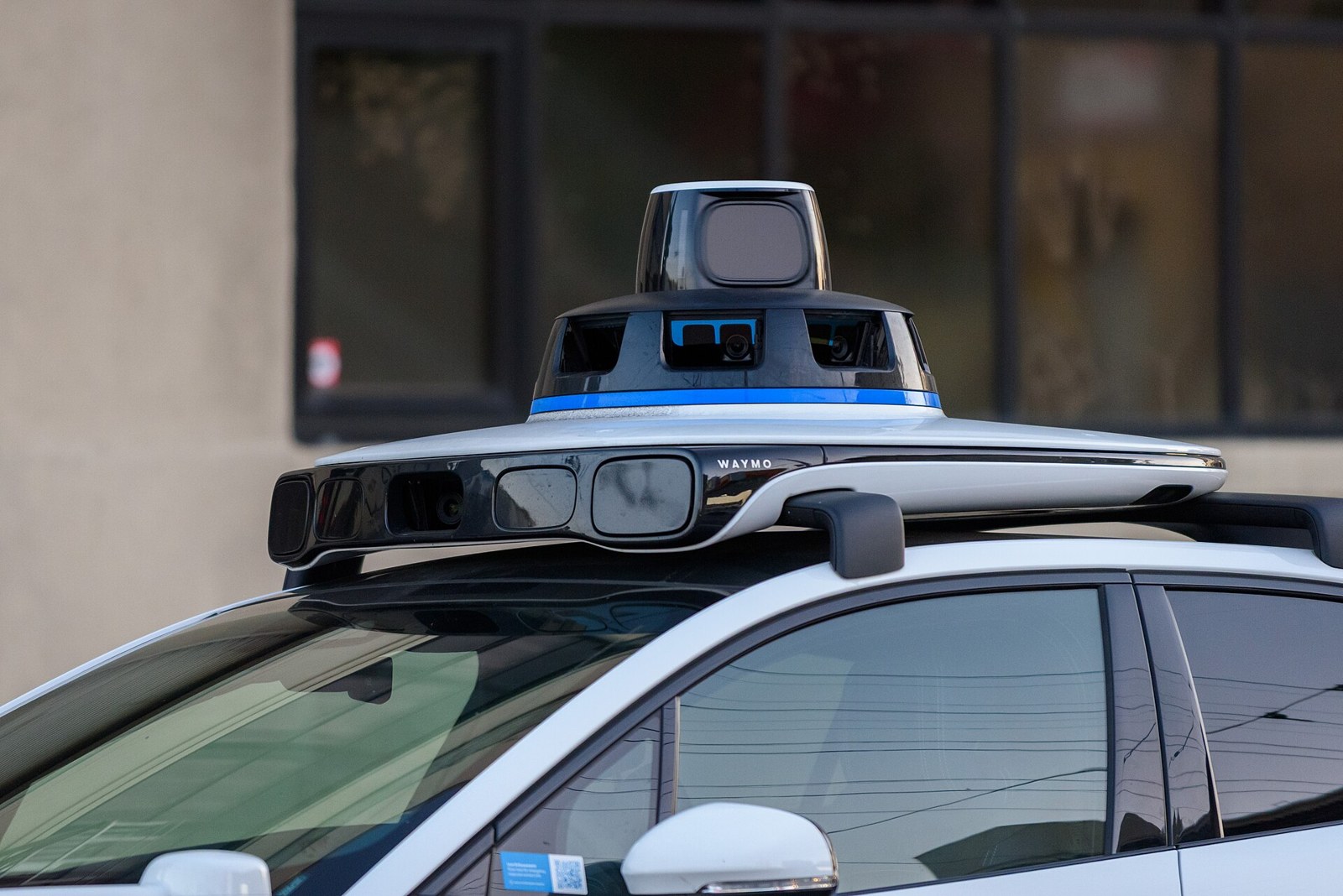 Waymo Heads for Madrid: What Europe's Robotaxi Race Really Tests in 2027 1 - Instant Vista Close-up of the rooftop lidar and camera sensor dome on a Waymo Jaguar I-PACE at a San Francisco stoplight